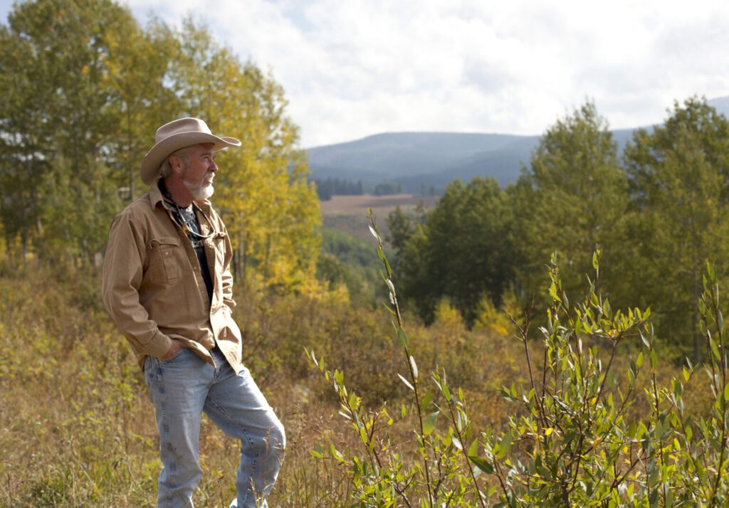 Bearded man in cowboy hat overlooking valley