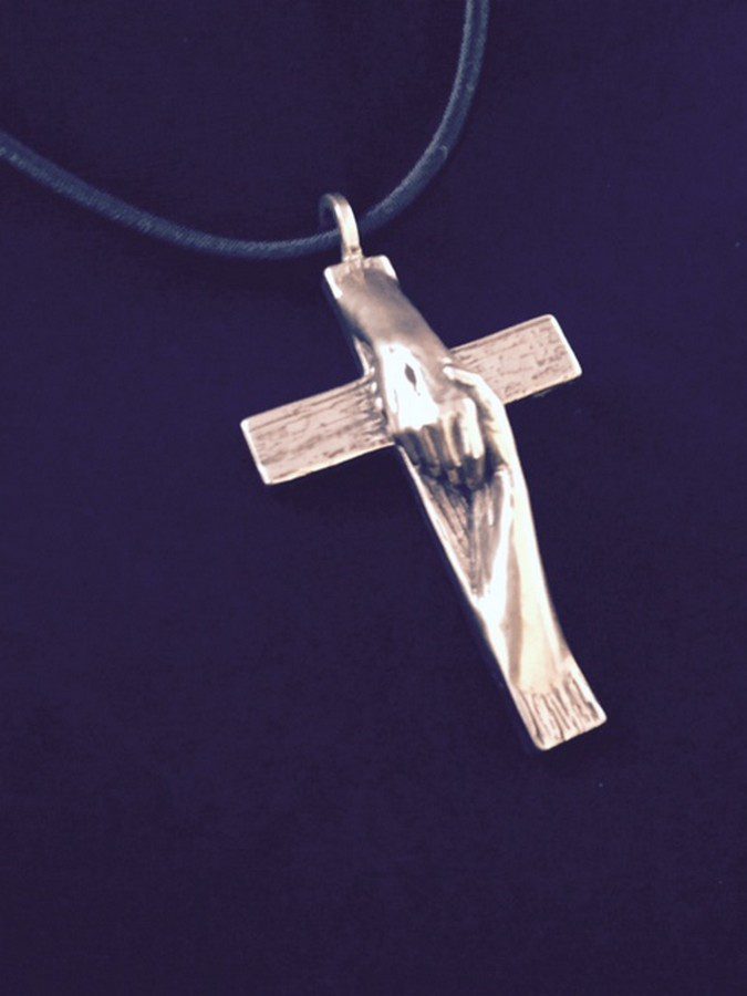 Tom White Studios, Inc | Cross Sculptures Calvary Jesus Rescued Statue Rescued Cross silver necklace created by Christian sculptor, Tom White. Depicts Jesus nail-scarred hand rescuing mankind by His great love shown on Calvary by His death and the power of His Resurrection. Available in necklaces and wall hangings.