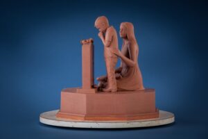 Small bronze monument showing mourning family