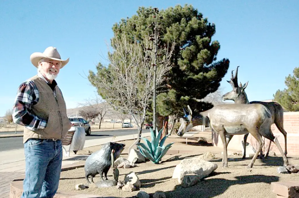 Man in hat with pronghorn sculptures