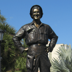 Bronze soldier statue outdoors, hands on hips