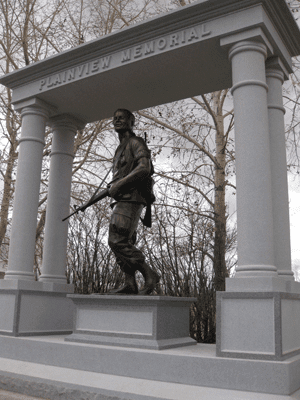Bronze Vietnam-era soldier statue under memorial arch