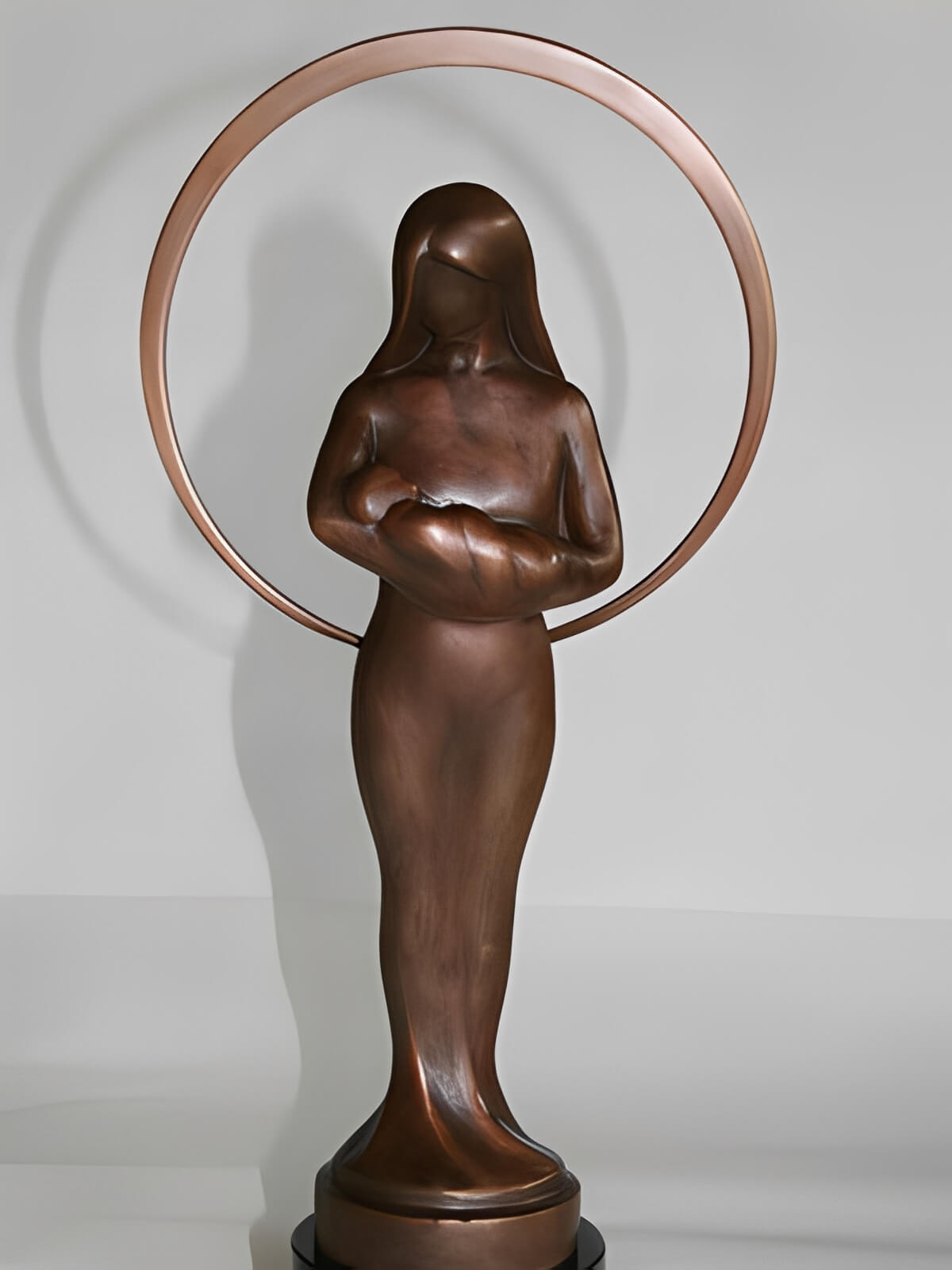 Bronze mother holding infant in ring