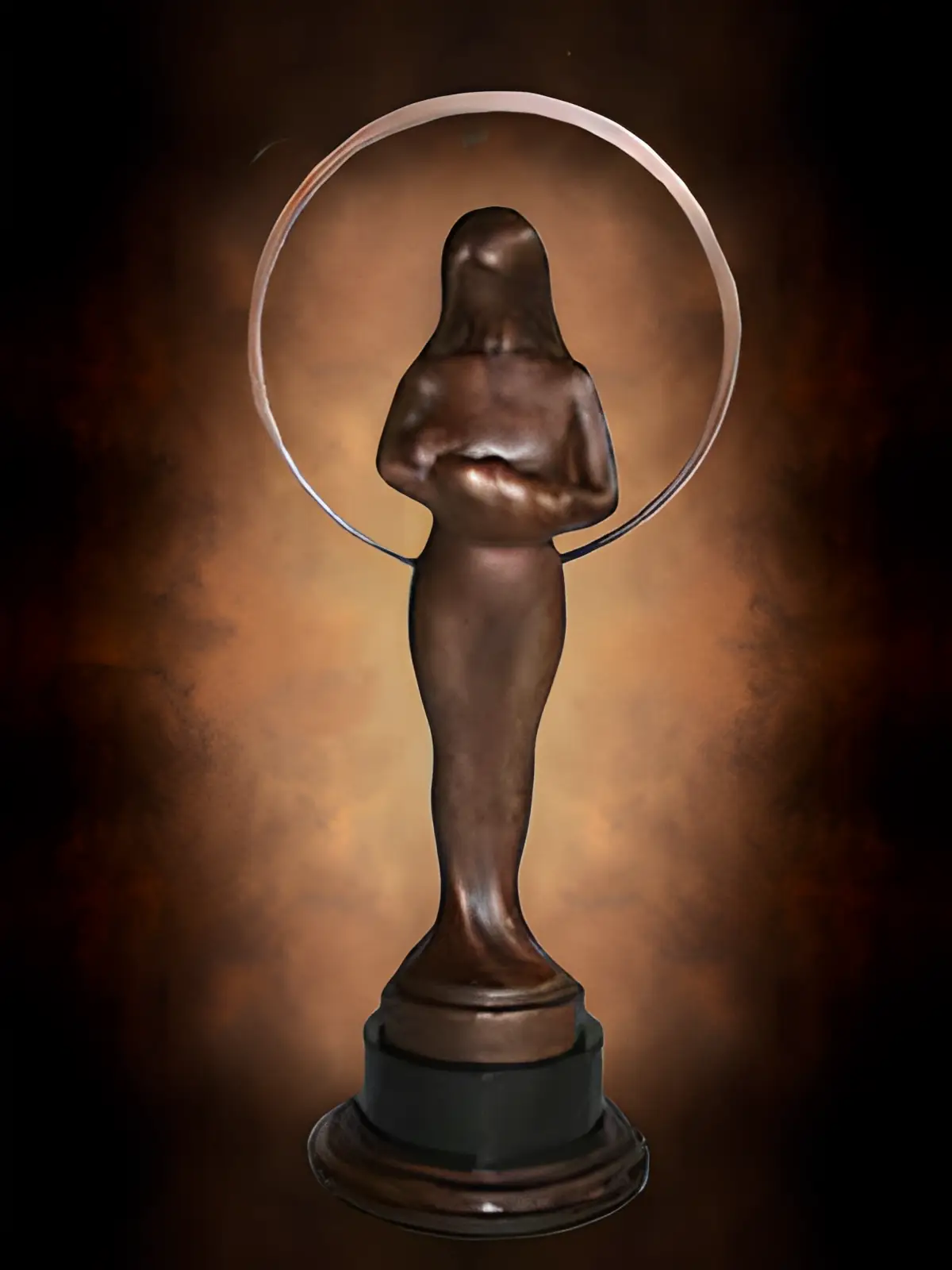 Bronze mother statue lit against dark backdrop