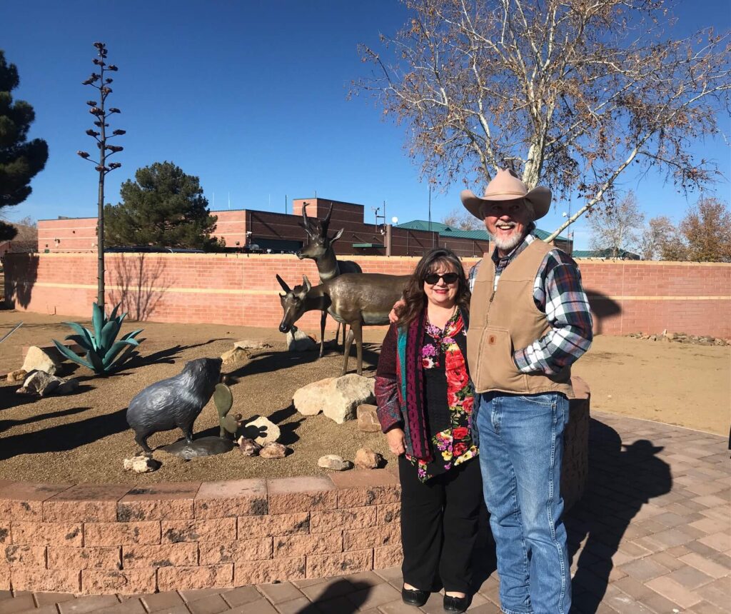 Couple beside outdoor bronze wildlife sculptures