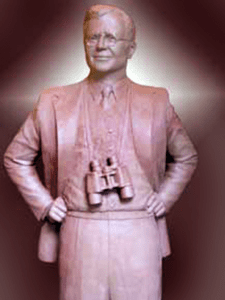 Bronze statue wearing binoculars, studio backdrop