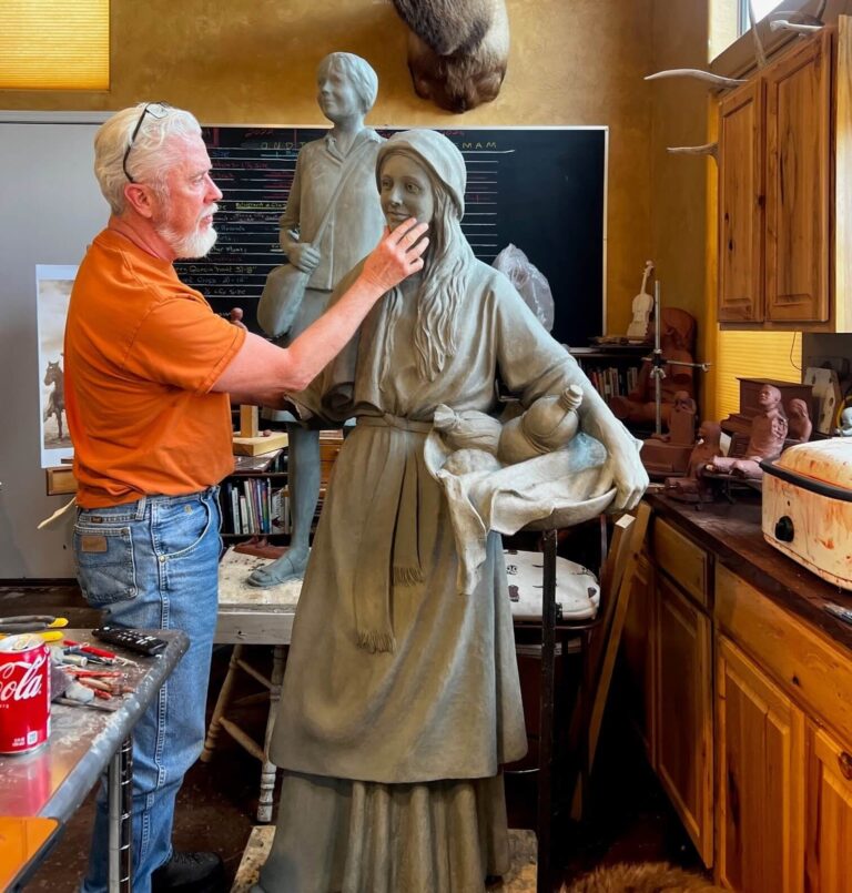 Artist shaping female bronze statue
