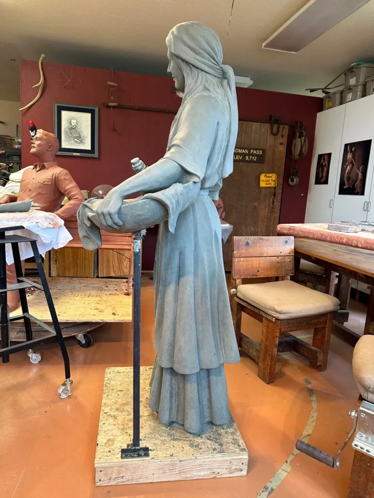 Standing bronze woman statue in workshop