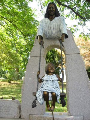 Tom White Studios, Inc | Jesus Statues Bronze girl on swing under Jesus arch