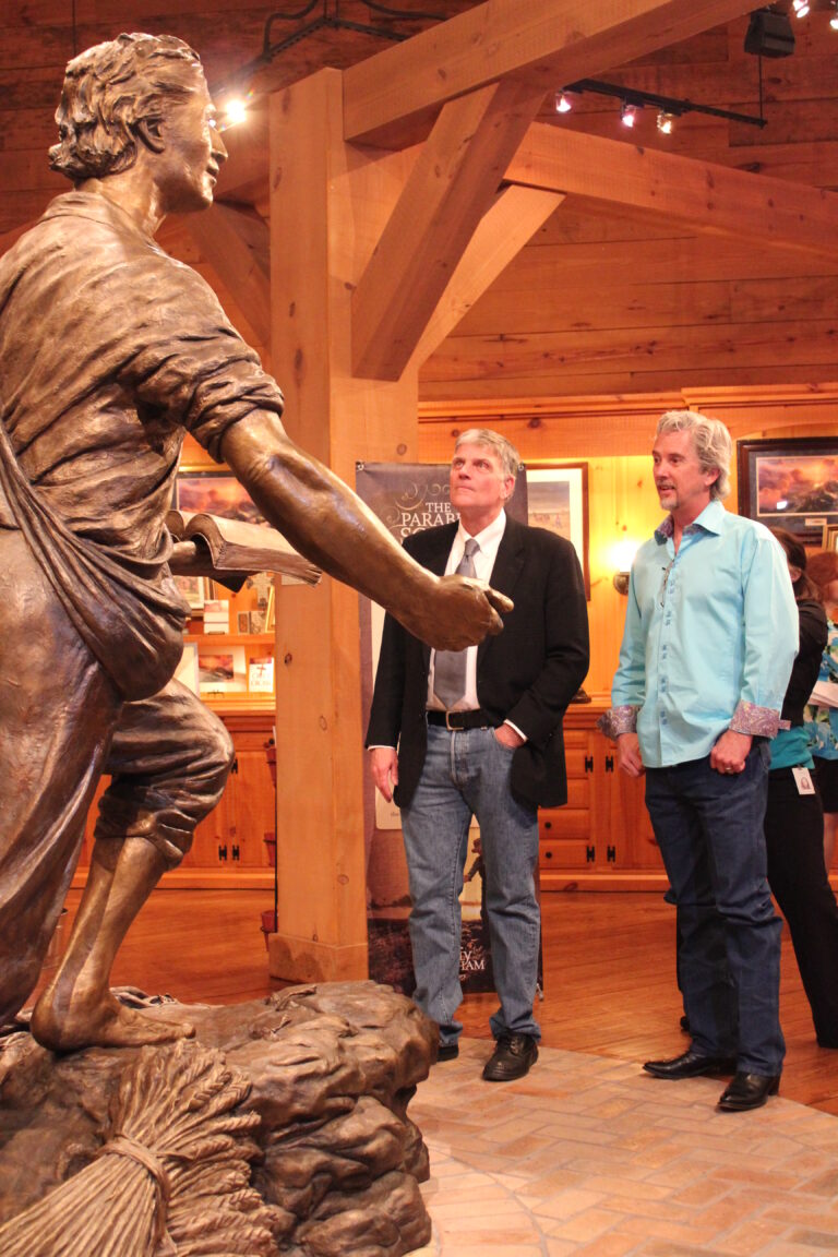 Bronze sower statue with visitors inside gallery